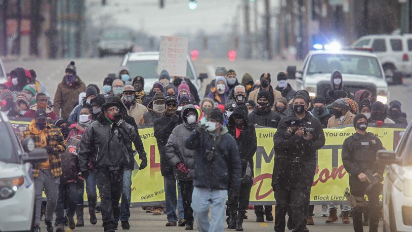 Snow flurries were falling Monday during a march on Martin Luther King Jr. Day. Around 100 people braved the cold for the march that started at Drew Health Center on West Third Street and ended at the Third Street bridge in Dayton.