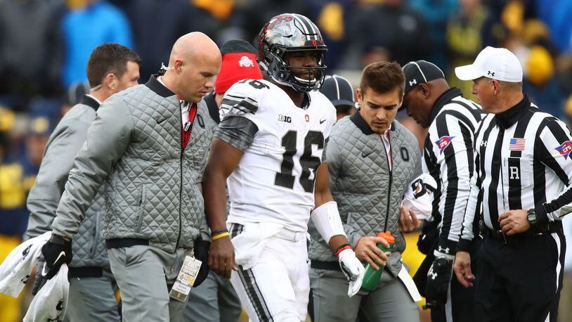 Ohio State quarterback J.T. Barrett injured his knee and left the game during the third quarter of Saturday's victory against Michigan. Barrett also hurt his knee before the game when he was bumped by a photographer on the sideline.