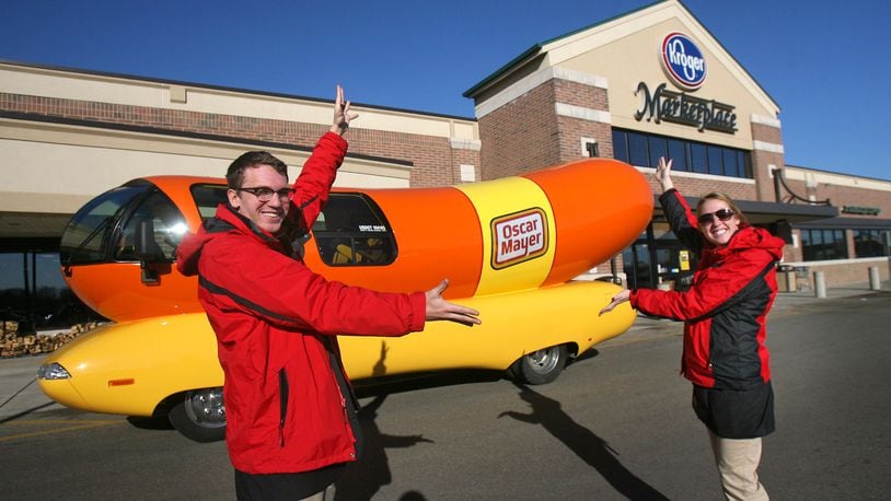 Hotdogger's Dylan Hackbarth (left) and Kylie Hodges stand with an Oscar Mayer Wienermobile outside the Kroger Marketplace in Liberty Twp., Ohio, Thursday, Jan. 6, 2012. This Wienermobile is one of a fleet of six vehicles touring the United States. The vehicle is 60 hot dogs in length (27 feet) and weighs 140,000 hot dogs (7 tons). Staff photo by Nick Daggy