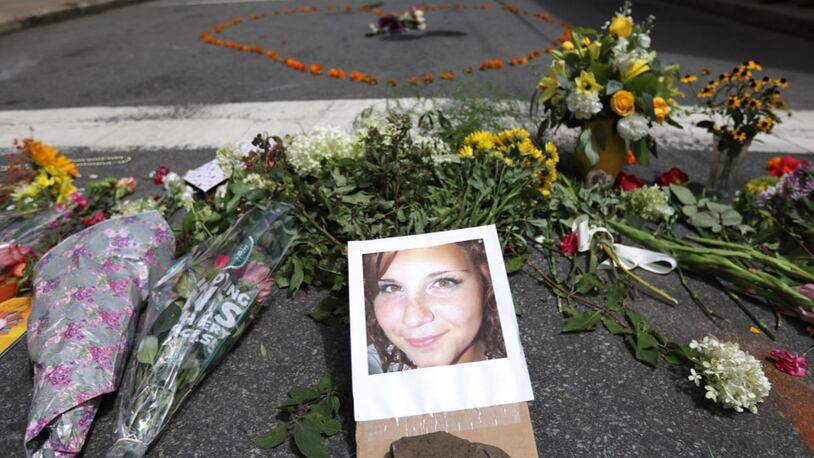 CHARLOTTESVILLE, VA - AUGUST 13:   Flowers surround a photo of 32-year-old Heather Heyer, who was killed when a car plowed into a crowd of people protesting against the white supremacist Unite the Right rally, August 13, 2017 in Charlottesville, Virginia. Charlottesville is calm the day after violence errupted around the Unite the Right rally, a gathering of white supremacists, that left Heyer dead and injured 19 others.