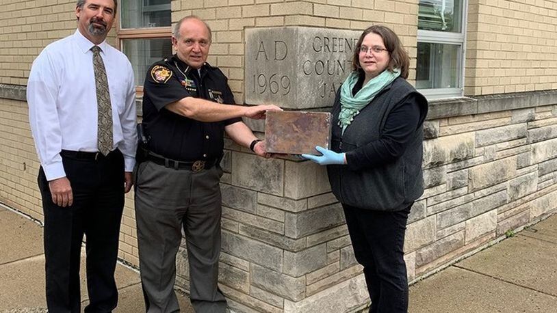 Greene County Administrator Brandon Huddleson, left, Sheriff Gene Fischer, middle, and County Records Manager Robin Heise stand with the 1969 time capsule that was recently removed from the cornerstone at the Greene County Jail. The time capsule will be opened Friday June 21. CONTRIBUTED