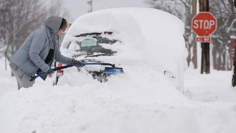 Chelse Volgyes clears snow from her car in Erie, Pa., Wednesday, Dec. 27, 2017. Freezing temperatures and below-zero wind chills socked much of the northern United States on Wednesday, and the snow-hardened city of Erie, dug out from a record snowfall.  (Jack Hanrahan/Erie Times-News via AP)