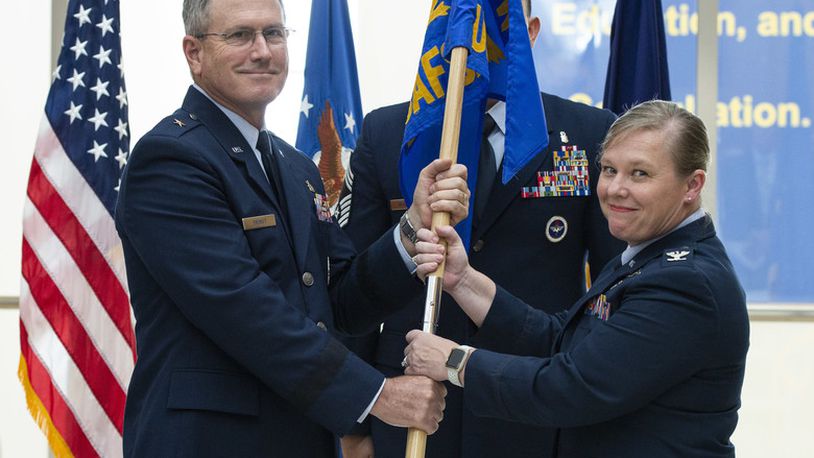 Brig. Gen. James Dienst, 711th Human Performance Wing commander, passes the U.S. Air Force School of Aerospace Medicine flag to Col. Theresa Goodman in a Change of Command ceremony July 19 to symbolize the change of command. (U.S. Air Force photo/Wesley Farnsworth)