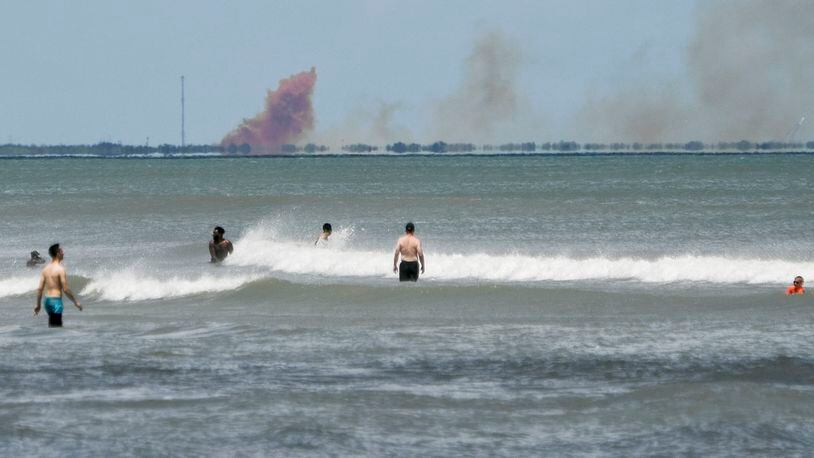 A cloud of orange smoke rises over nearby Cape Canaveral Air Force Station as seen from Cocoa Beach, Fla., Saturday, April 20, 2019. SpaceX reported an anomaly during test firing of their Dragon 2 capsule at their LZ-1 landing site. (Craig Bailey/Florida Today via AP)