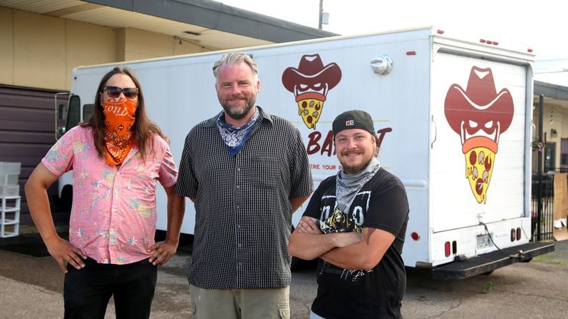 Brian Johnson, Mark Jeffers and James Burton (left to right) are the owners of the Pizza Bandit, a New York style pizza truck that can found at the Yellow Cab Tavern in Dayton.  LISA POWELL / STAFF