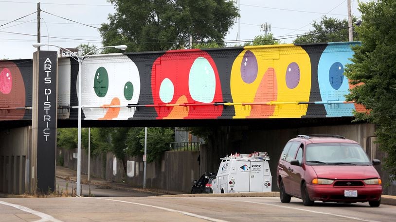 A whimsical mural of birds decorates the train overpass near the intersection of Keowee and First streets. LISA POWELL / STAFF
