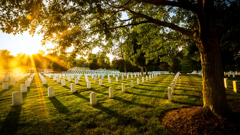 The sun begins to set over the graves of milirary personnel buried at Arlington National Cemetery.