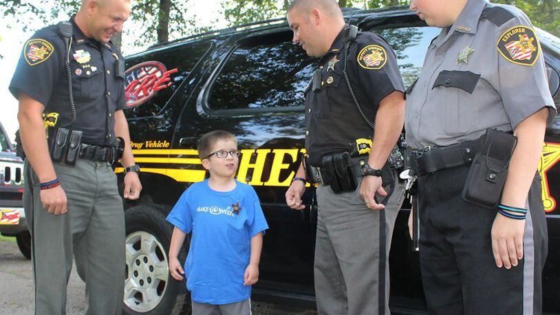 Paul Grandinette Jr. (second left) talks with Clark County Sheriff’s Deputies Josh Berner, Shaun Lisle and explorer Emily Adkins before they give him an escort to the county line. Grandinette is on his way to Disney World for his Make-A-Wish trip.