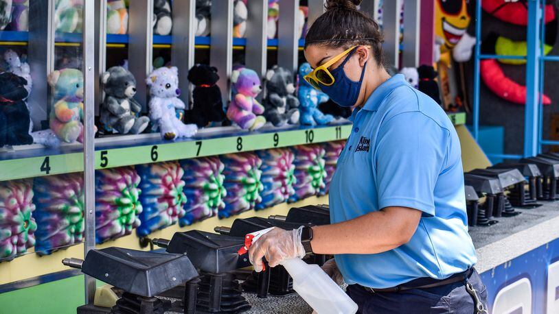 Kings Island opens to pass holders July 2 with numerous protocols in place to decrease the chance of spread of COVID-19. Guest must pre-register for admission to the park and are required to wear masks, get their temperature taken and stand in accordance with social distancing guidelines. There are also hundreds of hand sanitizers stations around the park and staff cleaning rides, games, restaurants and touch surfaces regularly. NICK GRAHAM / STAFF