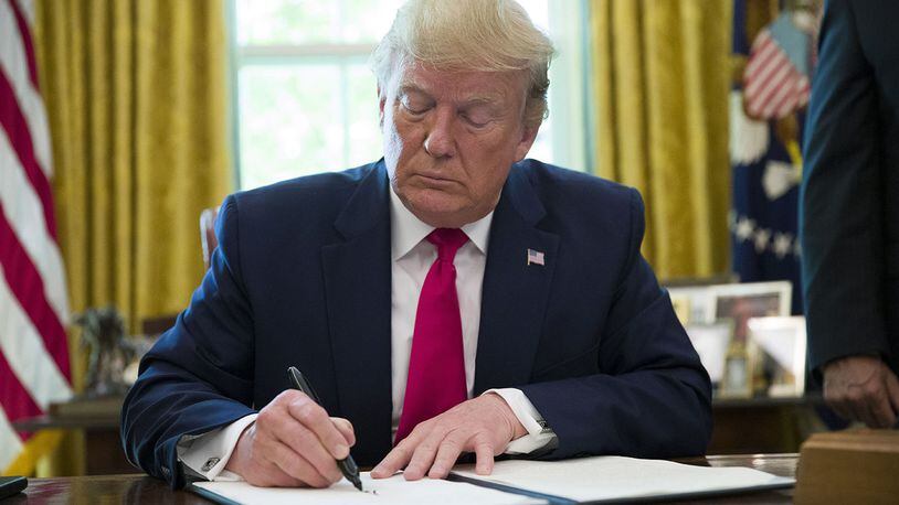 President Donald Trump signs an executive order to increase sanctions on Iran, in the Oval Office of the White House, Monday, June 24, 2019, in Washington.