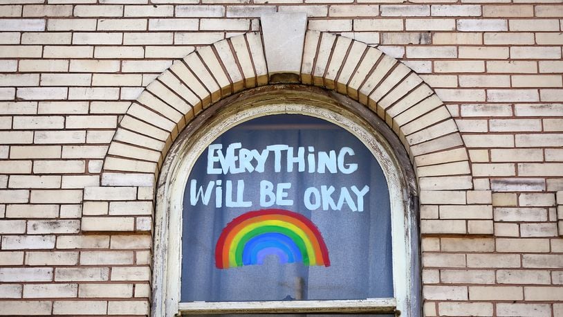“Everything Will be Okay,” fills a window of an apartment building on West Grand Avenue in Dayton. LISA POWELL / STAFF