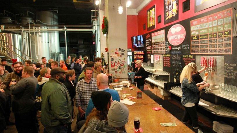 Warped Wing Brewing Company’s tasting room shortly after its 2014 opening at 26 Wyandot St. in downtown Dayton. Staff file photo by Jim Witmer