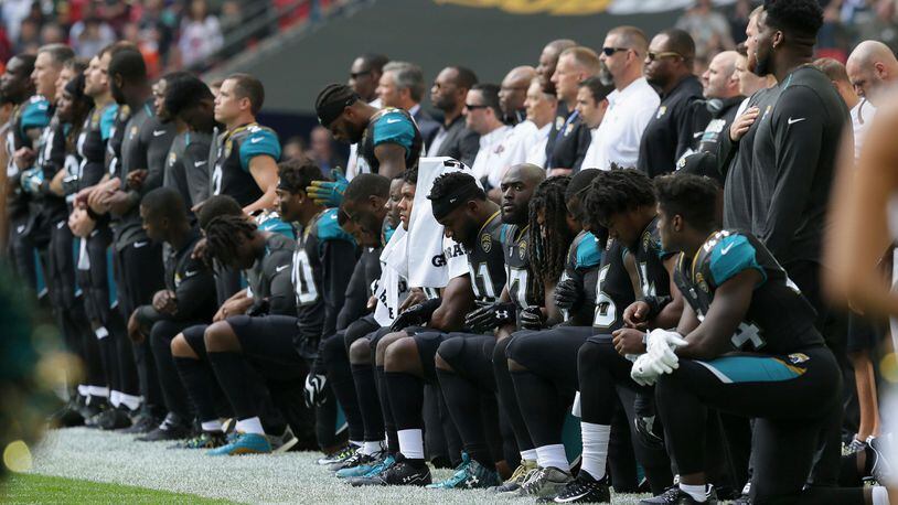 Jacksonville Jaguars players kneel down during the playing of the U.S. national anthem before an NFL football game against the Baltimore Ravens at Wembley Stadium in London, Sunday Sept. 24, 2017. (AP Photo/Tim Ireland)