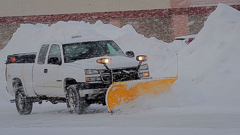 A snow plow works to clear the lot at the South Towne Center in Miami Twp. near the Dayton Mall Tuesday, Feb. 16, 2021. MARSHALL GORBY\STAFF