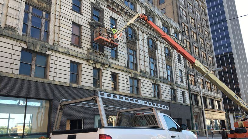 Crews work on the facade of the Dayton Arcade earlier this month. CORNELIUS FROLIK / STAFF