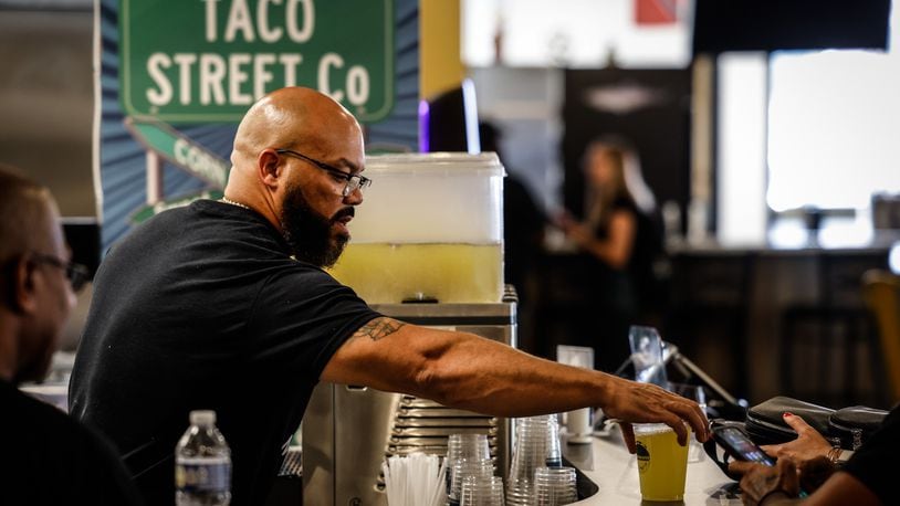 Taco Street Co. owner Anthony Thomas fixes drinks at his store inside W. Social Tap and Table at 1100 West Third St. JIM NOELKER/STAFF
