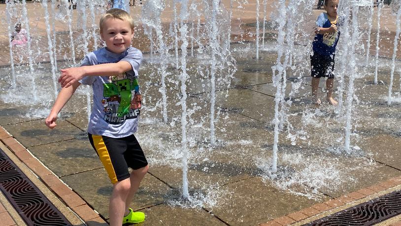 Sebastian Hartman, 7, plays in the water fountain at RiverScape MetroPark in downtown Dayton on Saturday. Eileen McClory / Staff