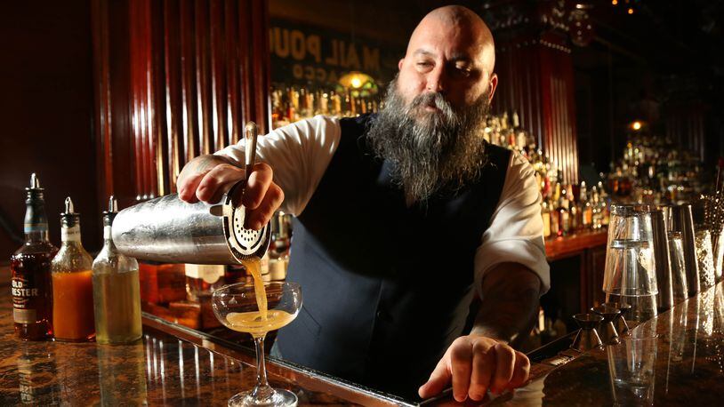 Century Bar co-owner Joe Head pours his seasonal cocktail the Sleepy Holler. JIM WITMER/STAFF