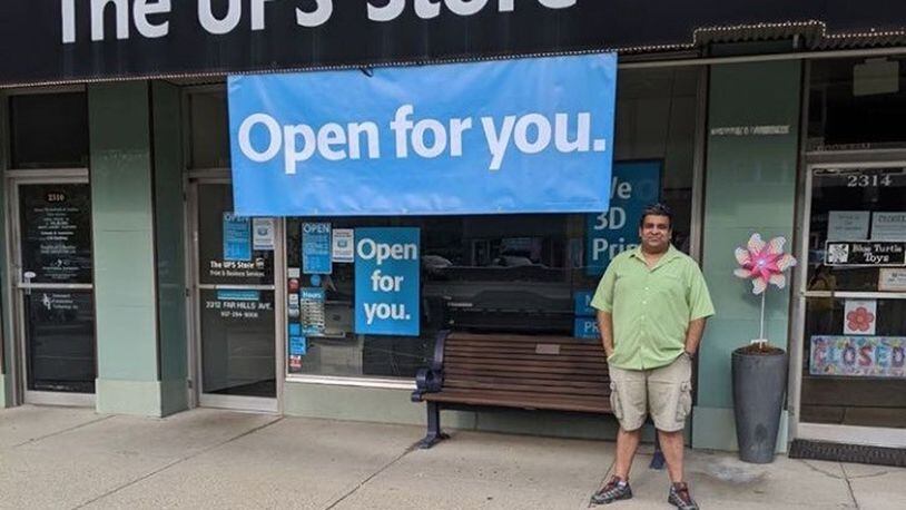 Ashwin Narayan, in front of his UPS store in Oakwood, is making free OPEN signs for businesses amid the coronavirus pandemic.