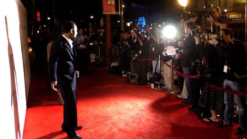 Springfield native John Legend poses for a wall of photographers as he walks down the red carpet to the Sony  party in Hollywood after winning three Grammy Awards in 2006. MARSHALL GORBY / STAFF