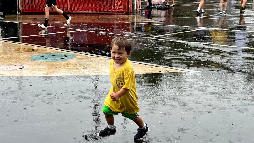 While some attendees to AlterFest on Saturday sought shelter from the rain under tents and umbrellas, Ari Lauwers, 2, relished in it. AIMEE HANCOCK/STAFF