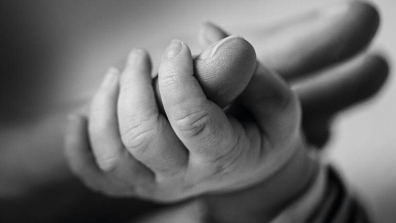 (This image has been converted to black and white) Close-up detail of an baby's hand holding a parent's finger, taken on February 28, 2014.