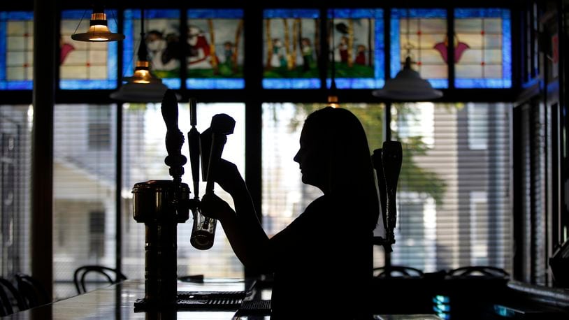 Emily Stephens, the catering manager at The Amber Rose Restaurant and Catering, a Dayton institution specializing in homemade Eastern European cuisine, pours a beer. LISA POWELL / STAFF