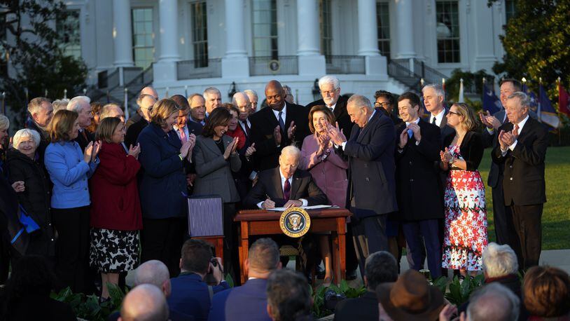 As Dayton Mayor Nan Whaley and members of Congress and other officials look on, President Joe Biden signs the $1 trillion infrastructure bill into law at the White House on Monday, Nov. 15, 2021. (Doug Mills/The New York Times)