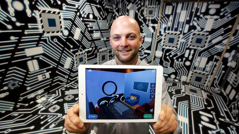 Furniture maker and retailer Ashley said Wednesday it is working with Kettering-based Marxent to create a company-wide “virtual reality and augmented reality strategy.” Barry Besecker, Marxent co-founder and chief technology officer, shows an example of the company’s mobile technology. TY GREENLEES/STAFF