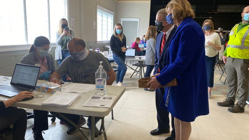 Ohio Gov. Mike DeWine and Ohio First Lady Fran DeWine (right) look on as Barry Gertner, 54, gets a COVID-19 vaccine at a vaccination clinic in Piqua. EILEEN McCLORY / STAFF