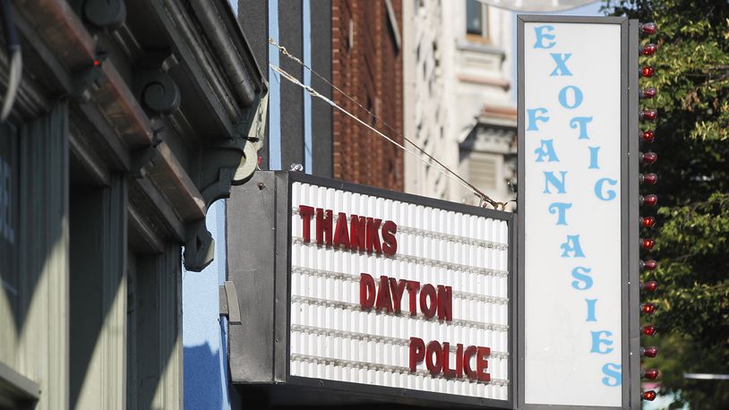 Memorials to the Dayton shooting victims filled the sidewalks of the Oregon District on Monday morning in the wake of 10 people being killed, including the shooter, and more than two dozen injured shortly after 1 a.m. Sunday. A sign recognizes the actions of six Dayton police officers who fired shots and killed the gunman as he tried to enter a bar. TY GREENLEES / STAFF