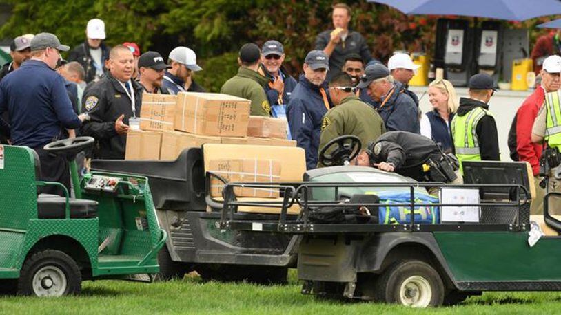 The golf cart that injured five people Friday is inspected by spectators during Friday's second round of the U.S. Open.