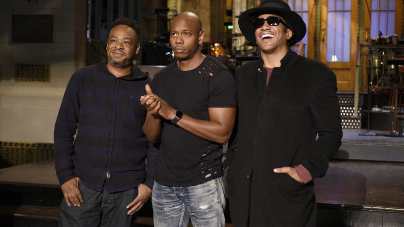 In this Nov. 10, 2016, photo released by NBC, Jarobi White and Q-Tip of musical guest A Tribe Called Quest pose with host Dave Chappelle, center, on the television show, "Saturday Night Live," in New York. (Rosalind O'Connor/NBC via AP)