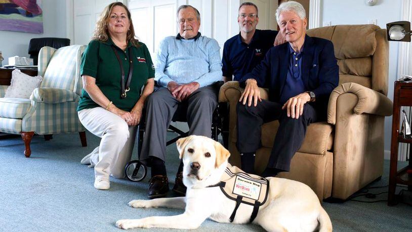 Former President George H.W. Bush, second left, poses for a photo with Sully, a yellow Labrador retriever who'll be his first service dog at his home in Kennebunkport, Maine, Monday, June 25, 2018. The 94-year-old and his new companion got acquainted Monday at the Bush family compound on the coast of Maine. Photographed with Bush are Valerie Cramer, from left, Brad Hubbard, from America's VetDogs, and former President Bill Clinton, visiting Bush. Sully was trained by the nonprofit that provides service dogs. (Evan F. Sisley/Office of George Bush via AP)
