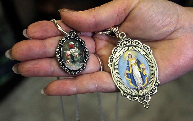 Mini-masterpieces by Centerville artist Cecilia Brendel come in the form of one- and two-inch ovals framed by a pendant.  LISA POWELL / STAFF