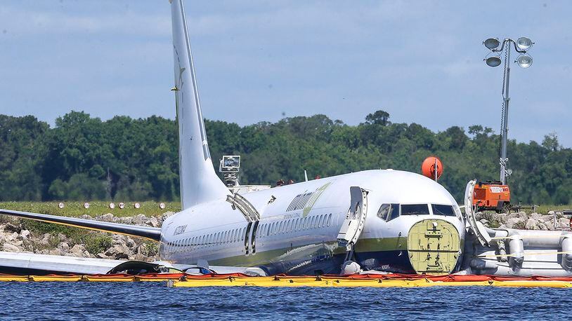 A charter plane carrying 143 people and traveling from Cuba to north Florida sits in a river at the end of a runway, Saturday, May 4, 2019 in Jacksonville, Fla.  The Boeing 737 arriving at Naval Air Station Jacksonville from Naval Station Guantanamo Bay, Cuba, with 136 passengers and seven aircrew slid off the runway Friday night into the St. Johns River, a NAS Jacksonville news release said. (AP Photo/Gary McCullough)