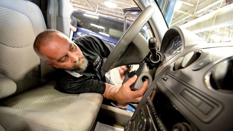 Auto technician Billy Morgan works on installing a new ignition switch during a recall repair on a Chevrolet HHR vehicle at Fitzgerald Auto Mall in 2014