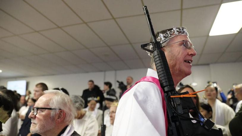 A church offical holds an AR-15 rifle  during a ceremony at the World Peace and Unification Sanctuary in Newfoundland, Pennsylvania on Wednesday.