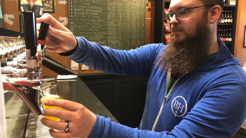 Gus Stathes, co-owner of The Barrel House at 417 E. Third St., pours a craft beer Sunday afternoon in downtown Dayton. Stathes said an extended forced shutdown due to the coronavirus could doom his business, although he sees why it might be necessary.