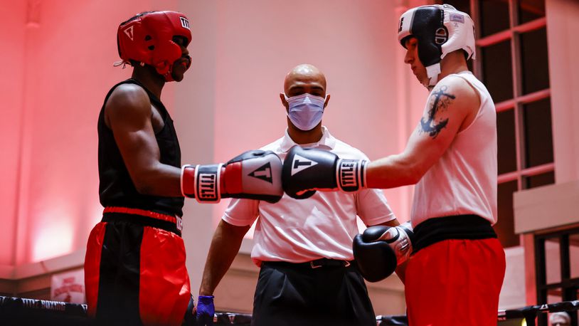 Referee Lonnie Scott oversees a boxing match between Cortez Wiseman, with red headgear, and Caden Jones, in white headgear, during "Friday Night Fights" amateur boxing held by Imhoff School of Boxing Friday, Jan. 14, 2022 at The Benison Events and Coworking Center in Hamilton. Wiseman won by decision. NICK GRAHAM / STAFF