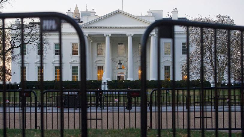 In this March 24, 2019 photo, The White House is seen behind security barriers in Washington. A White House official turned whistleblower says dozens of people in President Donald Trump's administration were granted access to classified information despite "disqualifying issues" in their backgrounds including concerns about foreign influence, drug use and criminal conduct.  (AP Photo/Cliff Owen)