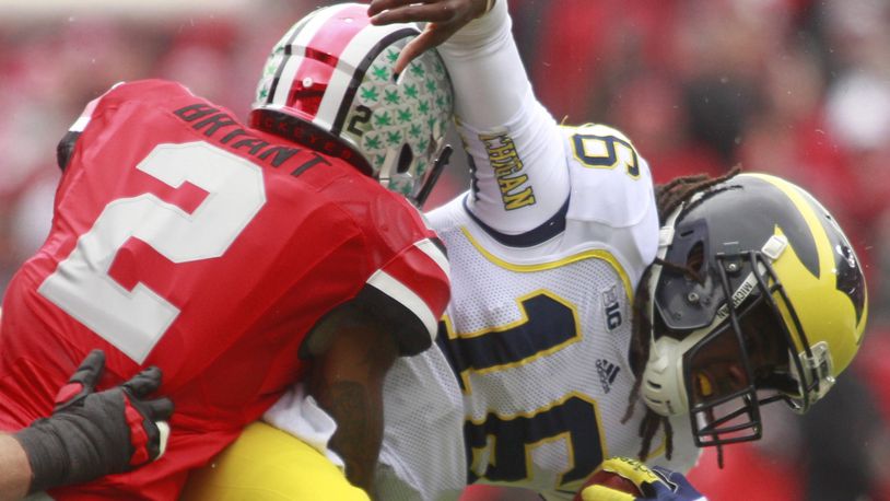 In this Nov. 24, 2012 photo, Denard Robinson (16) of Michigan is tackled by Christian Bryant (2) of Ohio State. Lest we forget: the Ohio State Buckeyes beat Michigan 26-21 that day to finish an undefeated 12-0 regular season. Staff file photo by Barbara J. Perenic