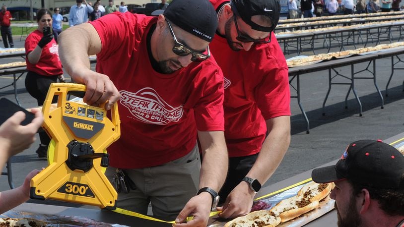 Twin brothers Jordan and Jake Shteiwi, owners of Steak Thyme Bar & Grill at 103 N. Springboro Pike in Miamisburg, celebrated the restaurant's first anniversary Wednesday, May 17, 2023, in a big way by constructing a 650.3-foot-long cheesesteak to beat a world record. MARSHALL GORBY\STAFF