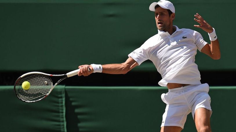 Serbia's Novak Djokovic returns a forehand to South Africa's Kevin Anderson in their men's singles final match at Wimbledon .