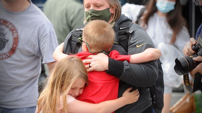 Major Erica Eyer, Receives hugs from two of her children Reagan, 8 and Brent, 5, After a two-month deployment administering COVID-19 vaccines in Michigan, Wright-Patterson Air Force Base Medical staff returned home Tuesday afternoon.