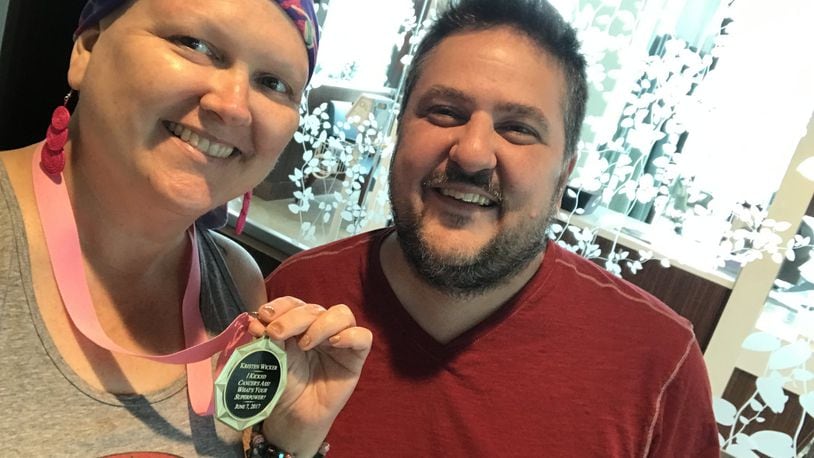 Kristen Wicker (left) and her partner and primary caregiver, Matthew Leclaire, on June 7, the last day of her chemo treatments at the Kettering Cancer Center. Kristen is holding a medal one of her closest friends gave her that day. CONTRIBUTED