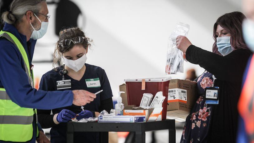 Premier Health workers prepare to vaccinate people from COVID-19 at an clinic held at the University of Dayton Arena Monday March 22, 2021.