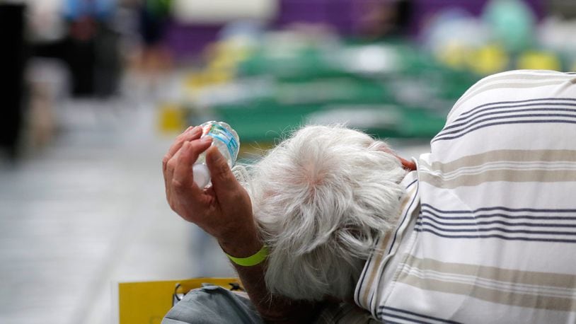 FILE PHOTO: A Hurricane Dorian evacuee holds a bottle of water as he rests on a cot in an evacuation shelter. A South Carolina child used his birthday money originally earmarked for a Disney trip to help evacuees escaping the storm.