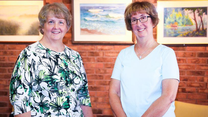 Bev Stolzenberger and Dianne Misins, daughters of Pat Brewer, pose with paintings their mother did that are part of a new exhibit of her work at the Middletown Arts Center.