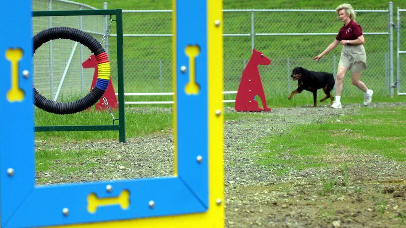 Nancy Ellis takes her Rottweiler Gracie through an obstacle course on the grounds of Montgomery County's Bark Park. STAFF FILE PHOTO